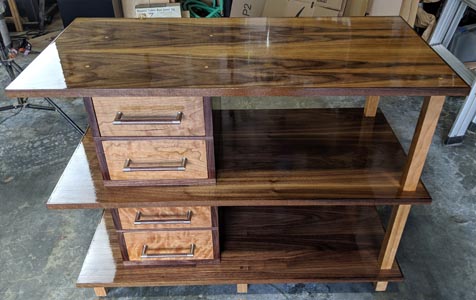 A unit with three shiny shelves and four drawers to store art supplies